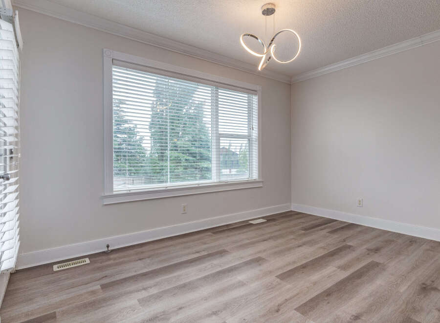 Experience modern living in this beautifully appointed room featuring elegant crown molding and a stylish contemporary chandelier.
