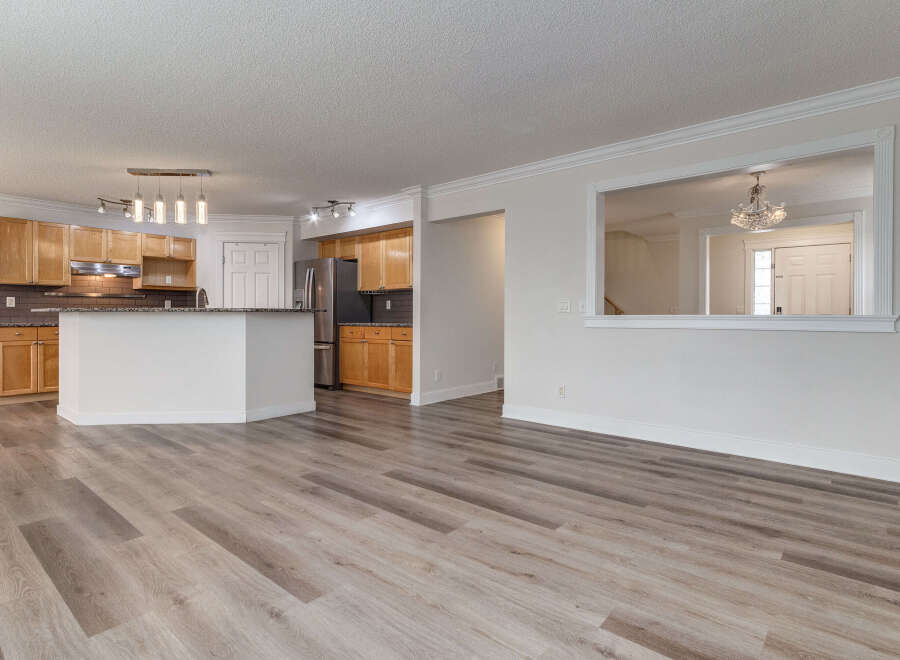 Discover this beautifully renovated open-concept living space, featuring a modern kitchen with sleek cabinetry and granite countertops.