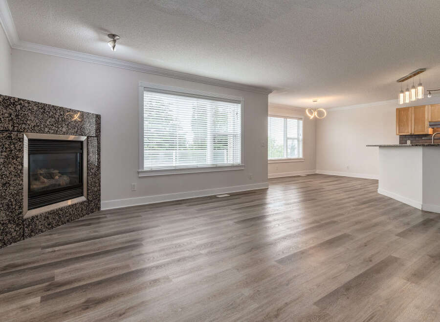 Experience modern living in this spacious open-concept home, featuring a striking granite fireplace as a focal point.
