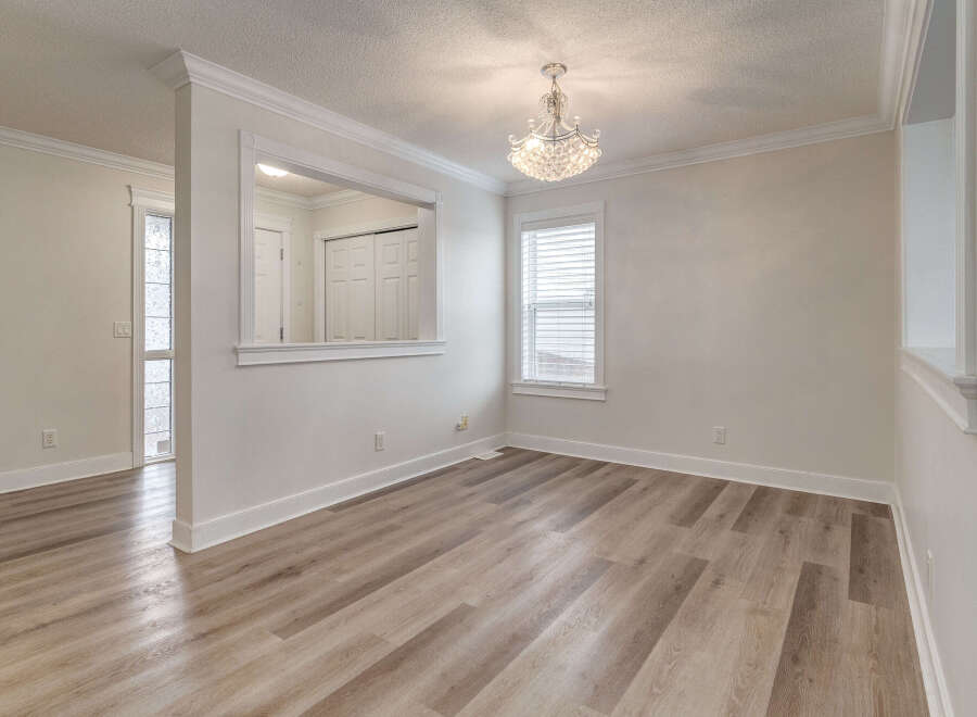 Step into this beautifully appointed dining area, featuring elegant crown molding and a stunning crystal chandelier that adds a touch of glamour.