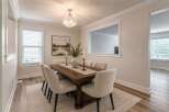 Experience elegant dining in this beautifully appointed space, featuring a spacious wooden table and comfortable upholstered chairs perfect for hosting.
