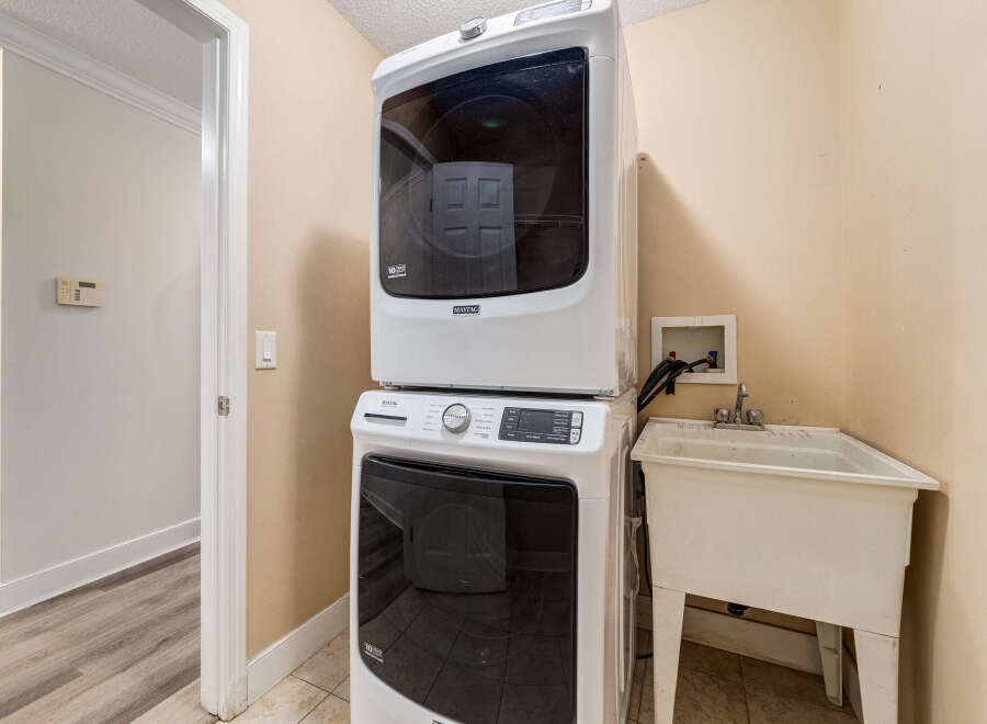 This laundry room features a stacked Maytag washer and dryer set, perfect for maximizing space.