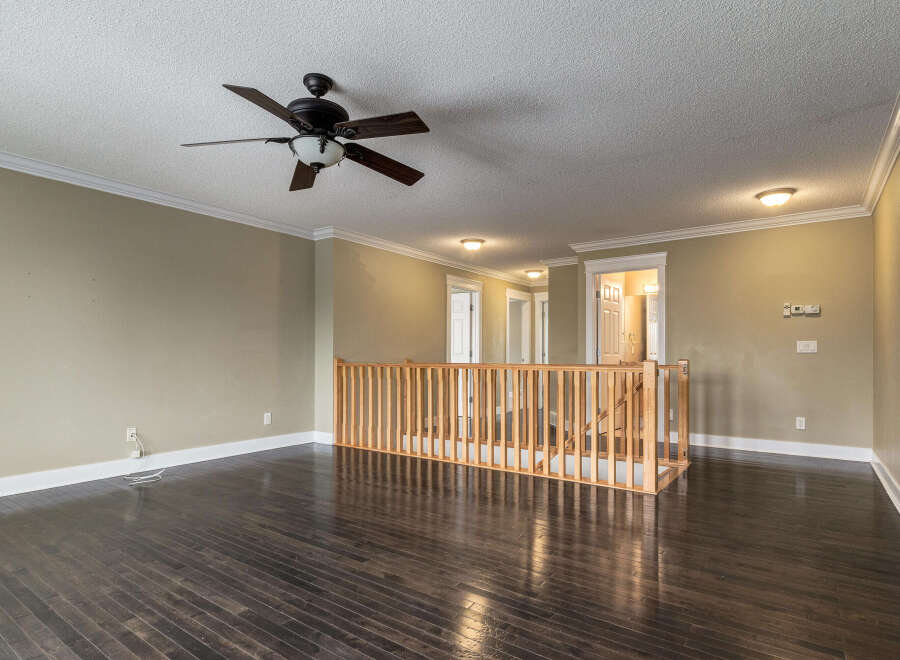 Step into this inviting living space featuring a sleek ceiling fan and rich, dark hardwood floors that gleam under recessed lighting.