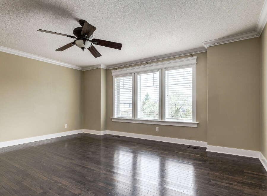 Experience spacious living in this beautifully appointed room, featuring rich dark hardwood floors that gleam under the natural light.