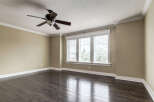 Experience spacious living in this beautifully appointed room, featuring rich dark hardwood floors that gleam under the natural light.