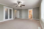 Step into this spacious bedroom featuring a ceiling fan for comfort and elegant crown molding throughout.