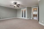 Step into this spacious room featuring a neutral carpet and a modern ceiling fan for comfort.