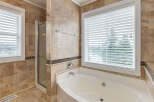 Indulge in luxury with this stunning bathroom featuring a spacious jacuzzi tub and a separate glass-enclosed shower.
