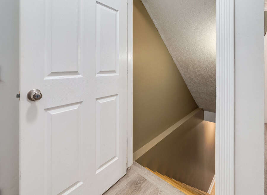 Discover the potential of this home with a partially open door revealing a staircase leading down to a finished basement.