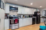 Discover this charming kitchen featuring sleek stainless steel appliances, including a microwave, oven, and dishwasher, complemented by ample white cabinetry for storage.