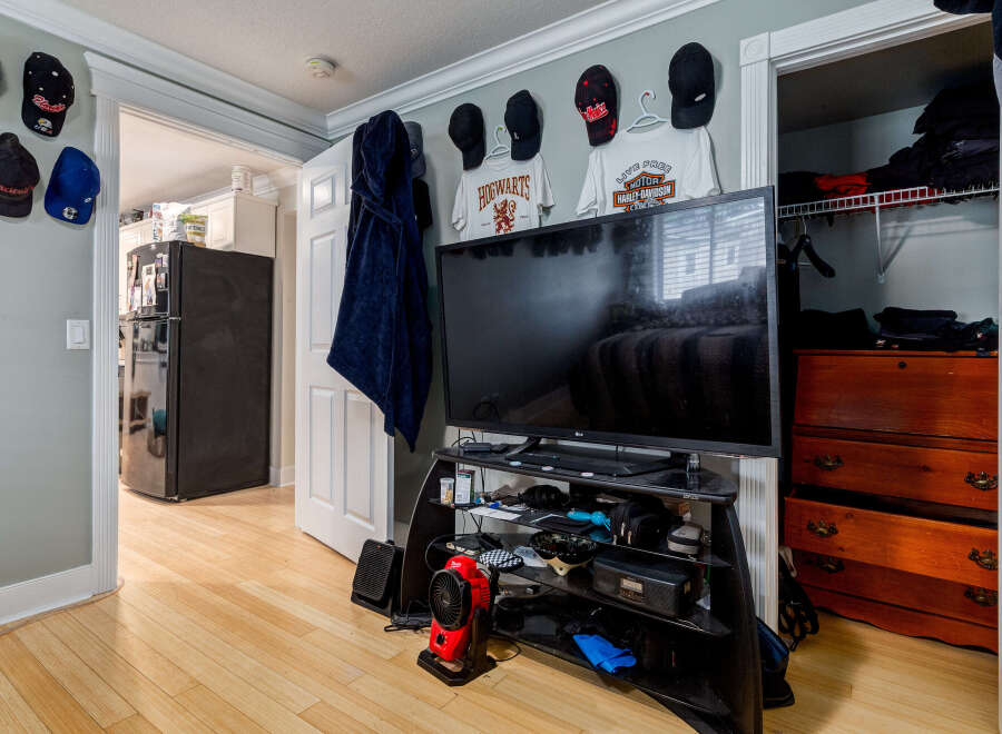 Discover a well-organized living space featuring a large flat-screen TV mounted above a media console, perfect for entertainment.