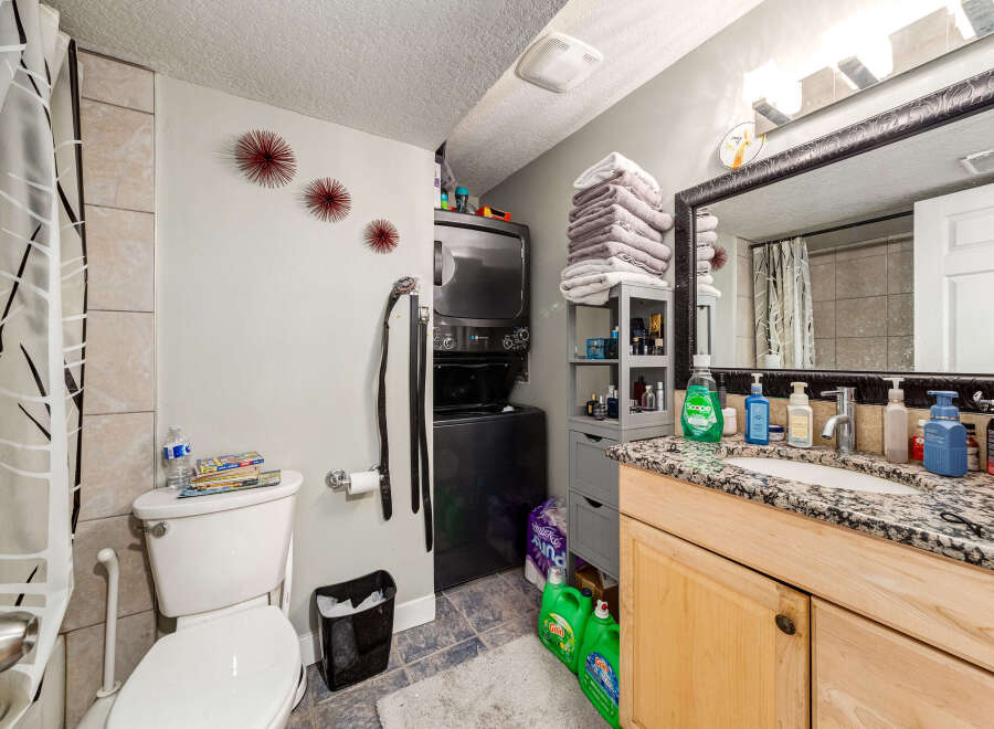 This bathroom features a stacked washer and dryer unit, perfect for maximizing space in a compact area.