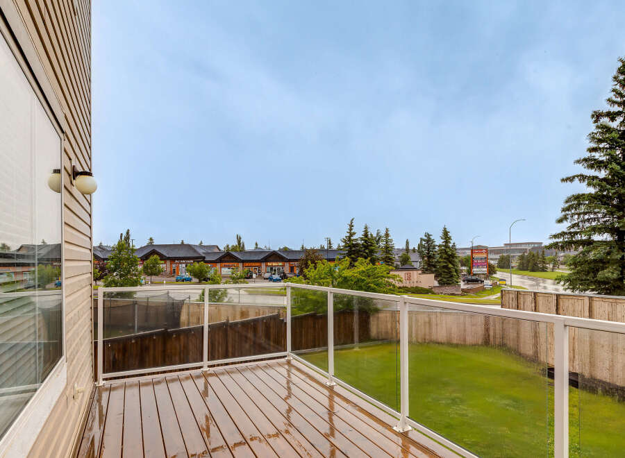 Enjoy outdoor living on this spacious wooden deck, complete with a modern glass railing offering unobstructed views.