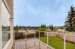 Enjoy outdoor living on this spacious wooden deck, complete with a modern glass railing offering unobstructed views.