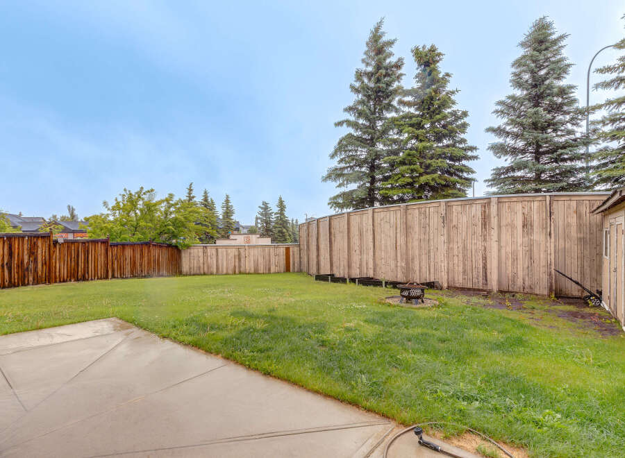Enjoy outdoor living in this spacious backyard, complete with a fire pit for cozy evenings and a concrete patio perfect for entertaining.