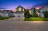 Experience twilight charm in this stunning blue home, featuring a grand arched window and a welcoming double garage.