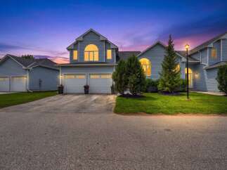 Experience twilight charm in this stunning blue home, featuring a grand arched window and a welcoming double garage.