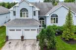 Discover this charming light blue home featuring a spacious two-car garage and elegant arched windows.