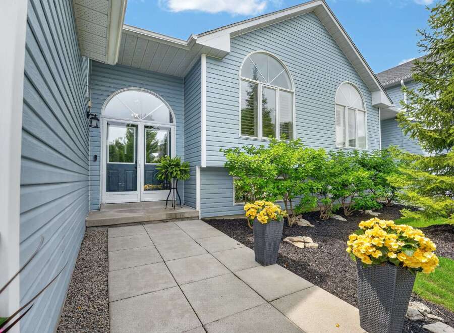 Welcome guests into this charming home through a beautiful arched entryway featuring double glass doors and a transom window.