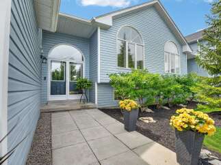 Welcome guests into this charming home through a beautiful arched entryway featuring double glass doors and a transom window.
