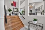 Step into this elegant home featuring a grand wooden staircase leading to the upper level.