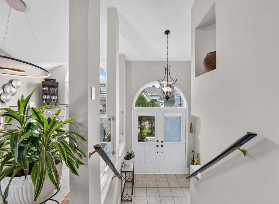 Step into a grand entryway featuring elegant double doors with arched transoms, flooding the space with natural light.