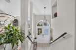 Step into a grand entryway featuring elegant double doors with arched transoms, flooding the space with natural light.