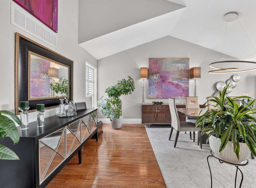 This elegant dining room features a vaulted ceiling and a large abstract painting that adds a pop of color.