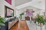 This elegant dining room features a vaulted ceiling and a large abstract painting that adds a pop of color.