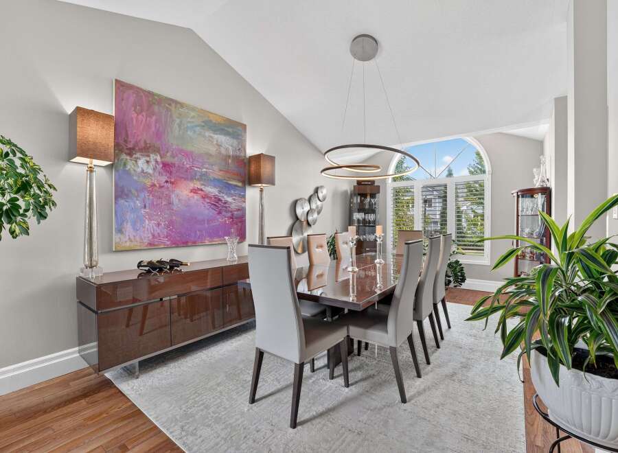 Experience elegant dining in this sophisticated space, featuring a large abstract artwork and a sleek, modern buffet.