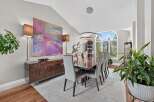 Experience elegant dining in this sophisticated space, featuring a large abstract artwork and a sleek, modern buffet.