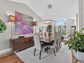 Experience elegant dining in this sophisticated space, featuring a large abstract artwork and a sleek, modern buffet.