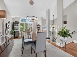 Experience elegant dining in this sophisticated space, featuring a sleek, modern dining set with plush upholstered chairs.