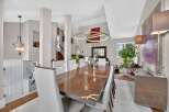 Experience elegant dining in this sophisticated space, featuring a sleek, high-gloss dining table surrounded by plush white chairs.