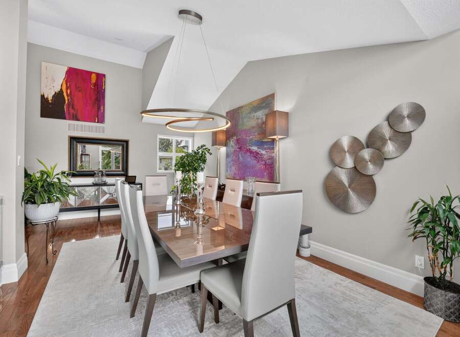 Experience elegant dining in this sophisticated space, featuring a stunning high-gloss dining table paired with plush, modern chairs.