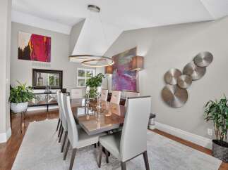 Experience elegant dining in this sophisticated space, featuring a stunning high-gloss dining table paired with plush, modern chairs.