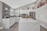Experience modern luxury in this stunning kitchen, featuring sleek white cabinetry and a breathtaking marble island.