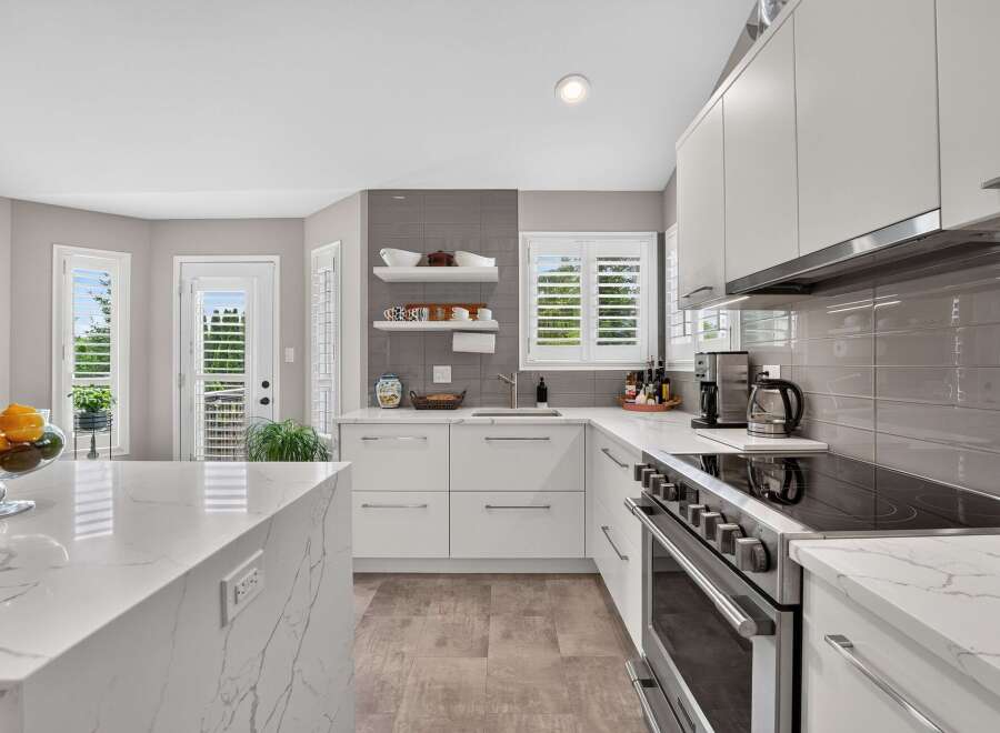 Experience modern living in this stunning kitchen featuring sleek white cabinetry and elegant quartz countertops.