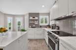 Experience modern living in this stunning kitchen featuring sleek white cabinetry and elegant quartz countertops.