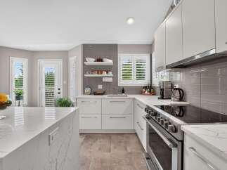 Experience modern living in this stunning kitchen featuring sleek white cabinetry and elegant quartz countertops.