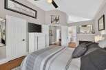Experience luxury and comfort in this stunning master bedroom, featuring a vaulted ceiling and a cozy fireplace.