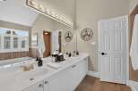 Experience luxury in this stunning bathroom featuring a spacious double vanity with elegant gold fixtures and ample counter space.