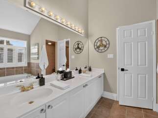 Experience luxury in this stunning bathroom featuring a spacious double vanity with elegant gold fixtures and ample counter space.
