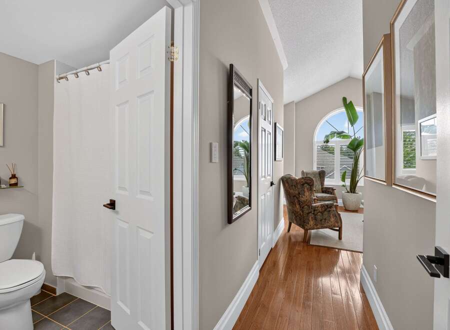 Step into this inviting hallway, featuring a bright and airy living space with large arched windows and comfortable seating.
