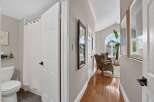 Step into this inviting hallway, featuring a bright and airy living space with large arched windows and comfortable seating.