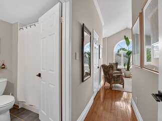 Step into this inviting hallway, featuring a bright and airy living space with large arched windows and comfortable seating.