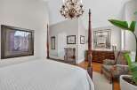 Experience luxury in this master suite featuring a grand four-poster bed and a stunning crystal chandelier.