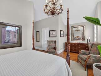 Experience luxury in this master suite featuring a grand four-poster bed and a stunning crystal chandelier.