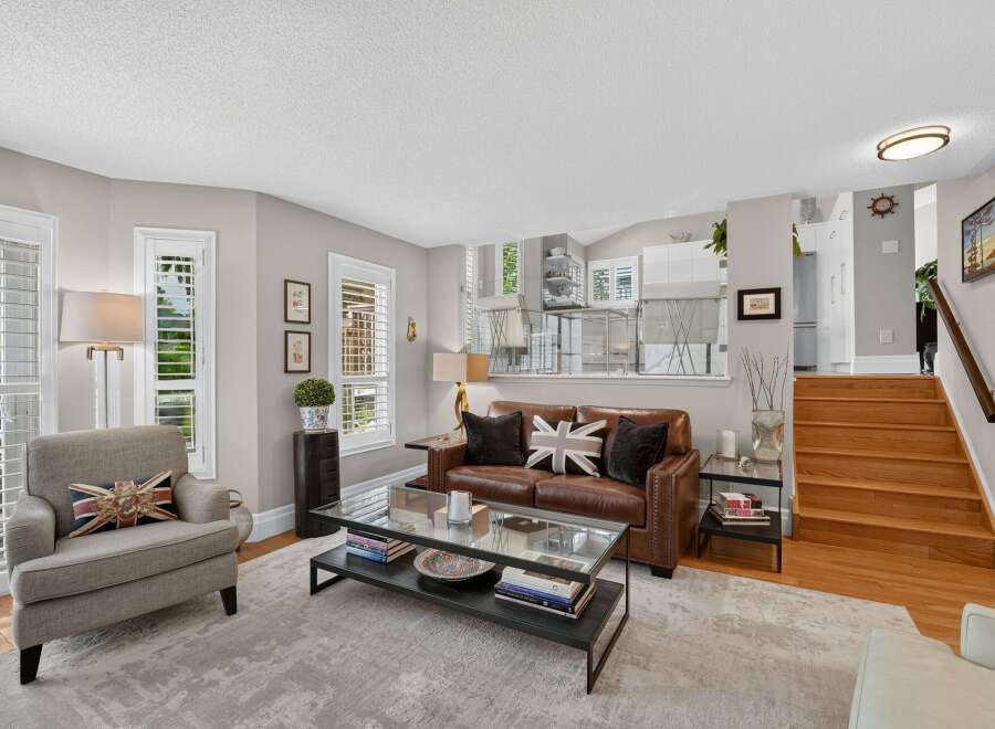 Step into this inviting living space featuring a plush leather sofa adorned with Union Jack pillows, complemented by a comfortable armchair.