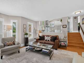 Step into this inviting living space featuring a plush leather sofa adorned with Union Jack pillows, complemented by a comfortable armchair.
